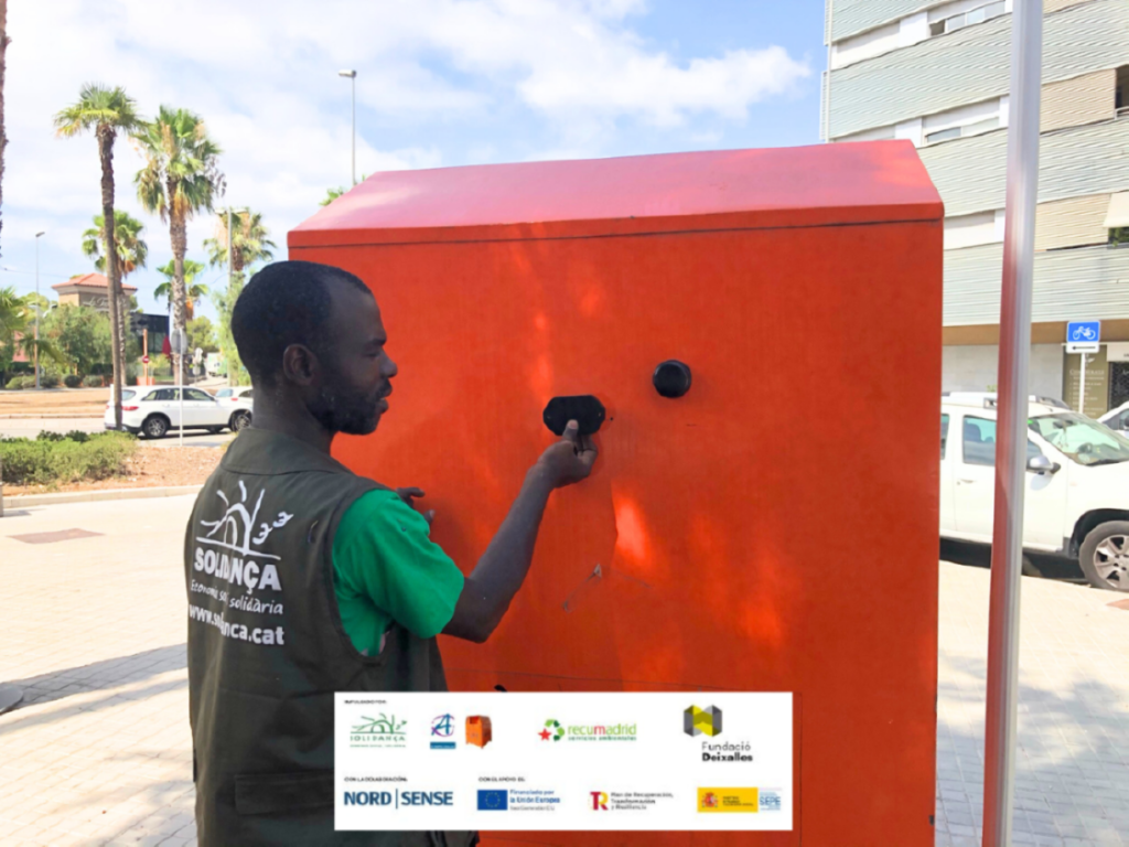 Trabajador de Solidança instalando un sensor volumétrico en un contenedor naranja de Roba Amiga